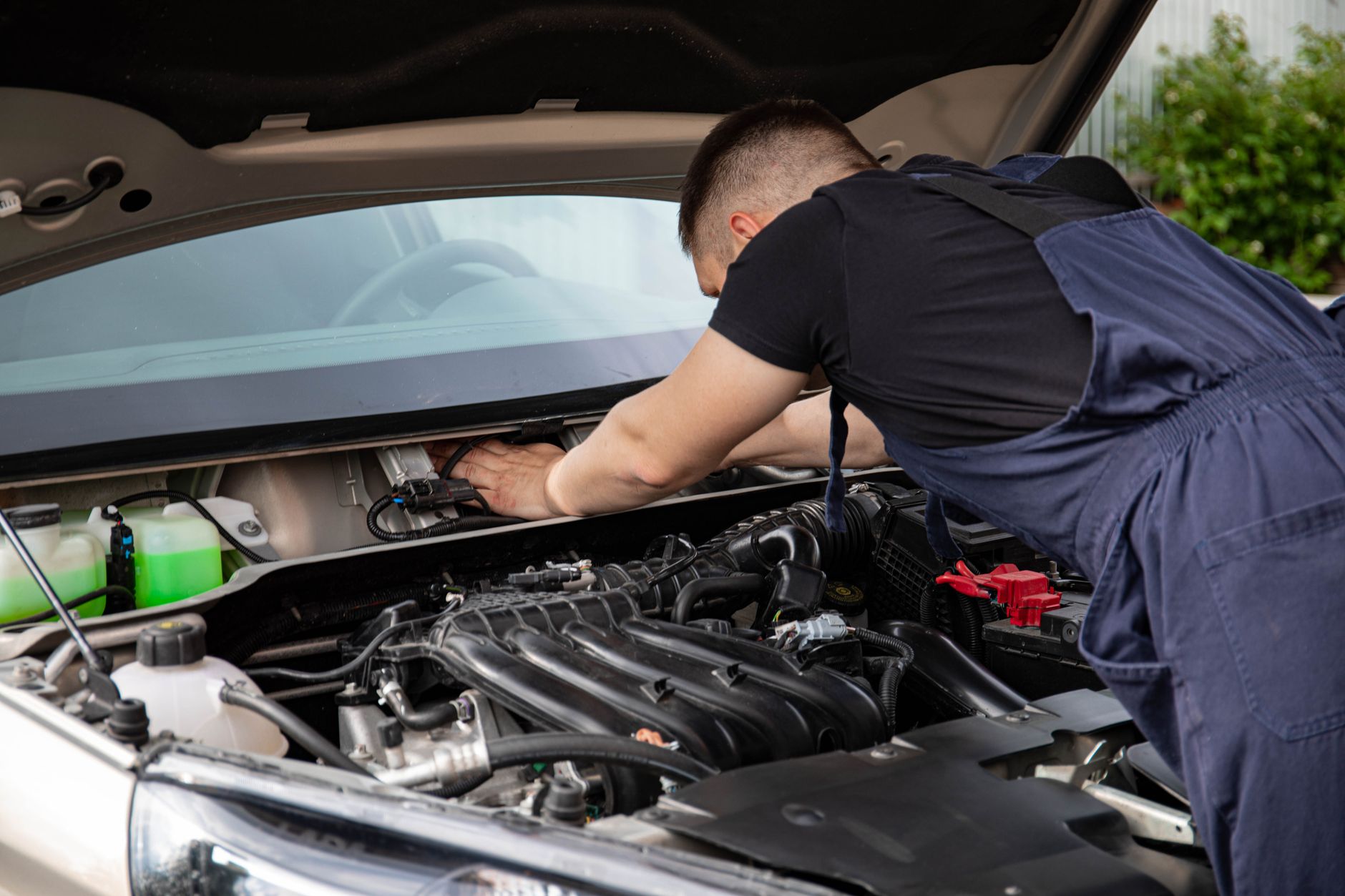Mecânico revisando o motor de um carro com o capô aberto